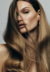 Woman with voluminous wavy blonde and brown hair, showing a smooth blow dry finish