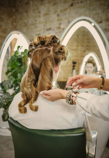 Stylist setting curls with clips during a blow dry workshop at Duck & Dry
