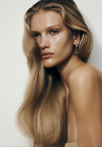 Front portrait of a woman with voluminous wavy blonde hair, styled with a blow dry