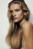 Front portrait of a woman with voluminous wavy blonde hair, styled with a blow dry