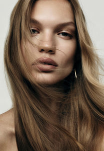 Front portrait of a woman with long, sleek light brown hair with subtle blonde tones