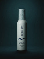 Bottle of 'Duck & Dry' hair product on a dark background