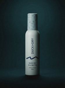 Bottle of 'Duck & Dry' hair product on a dark background
