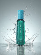 Duck & Dry Sea Salt Styler spray bottle with water splashes on a gray background