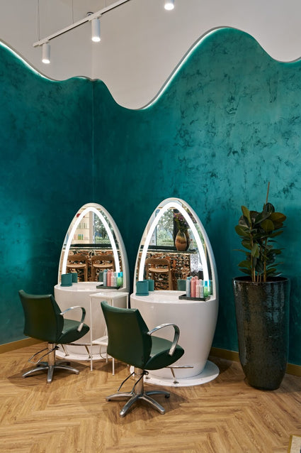 Styling area inside Duck & Dry, showing two mirrors and green leather chairs