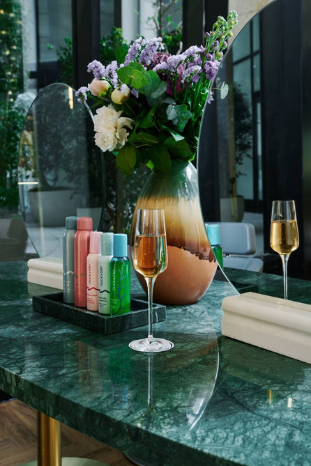 Duck & Dry styling station with a glass of prosecco, product tray and fresh flowers