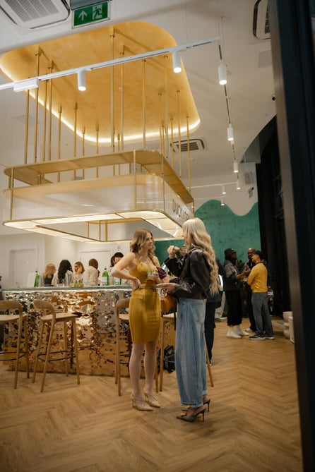 Guests with drinks beside the bar at a Duck & Dry salon event